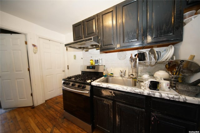 kitchen with exhaust hood, sink, decorative backsplash, dark hardwood / wood-style flooring, and stainless steel range with gas stovetop