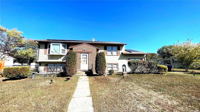 raised ranch featuring a front lawn