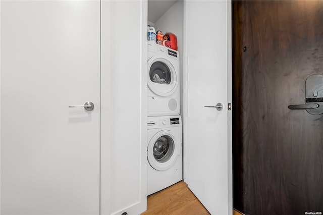 clothes washing area with light wood-type flooring and stacked washer and dryer