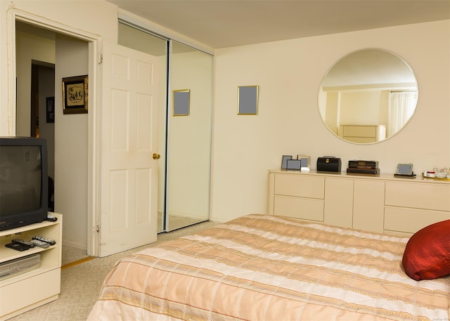 bedroom featuring light colored carpet and a closet