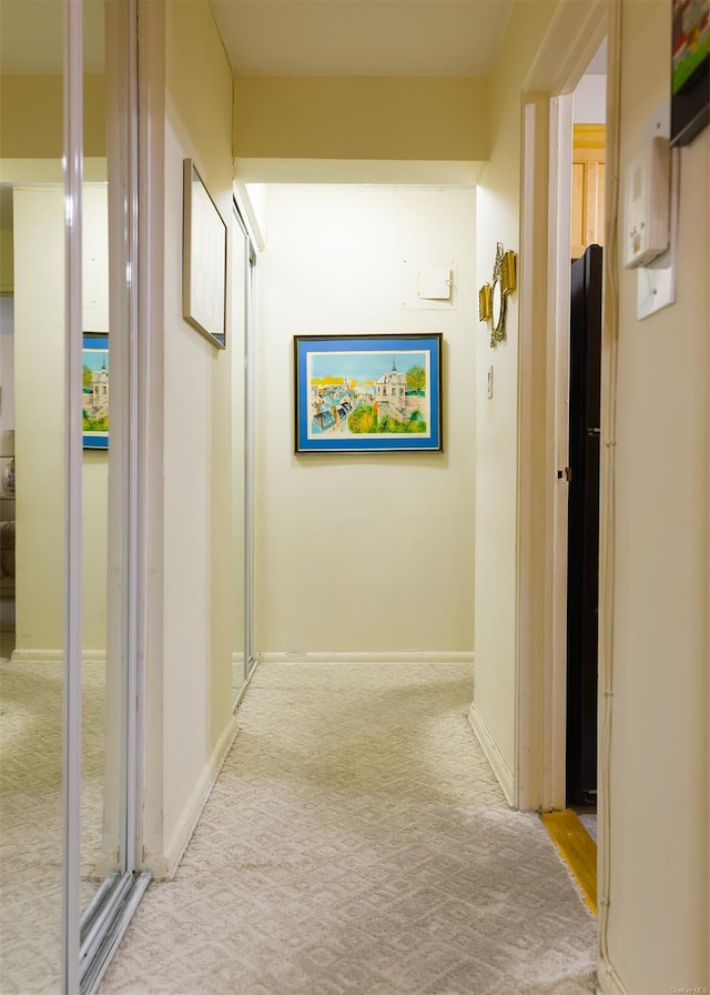 corridor featuring light colored carpet