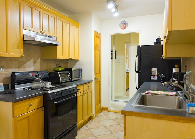 kitchen with tasteful backsplash, sink, black appliances, light tile patterned floors, and light brown cabinets