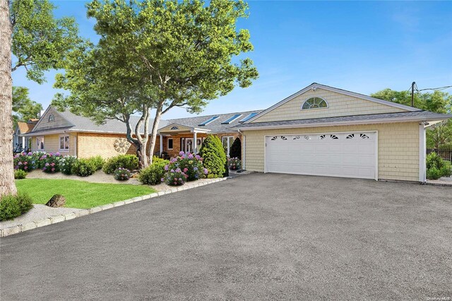 ranch-style home with solar panels and a garage