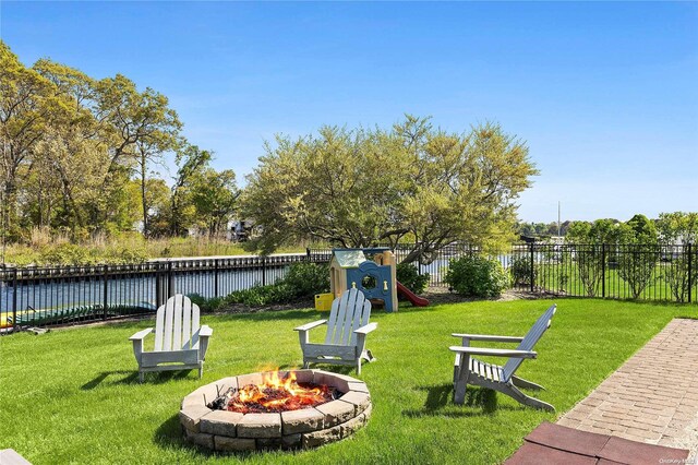 view of yard featuring a water view and an outdoor fire pit