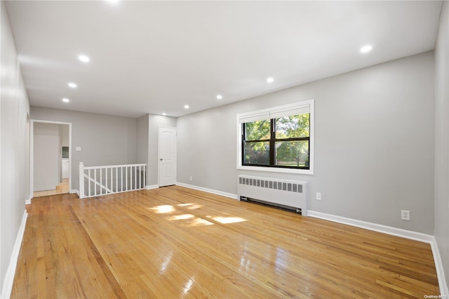 empty room with radiator and light hardwood / wood-style floors