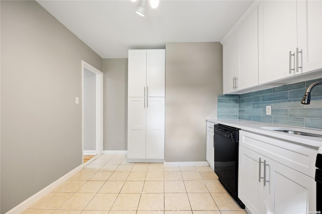 kitchen featuring backsplash, white cabinets, sink, black dishwasher, and light tile patterned flooring