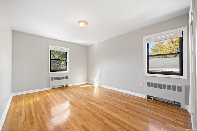 empty room featuring radiator and light hardwood / wood-style floors