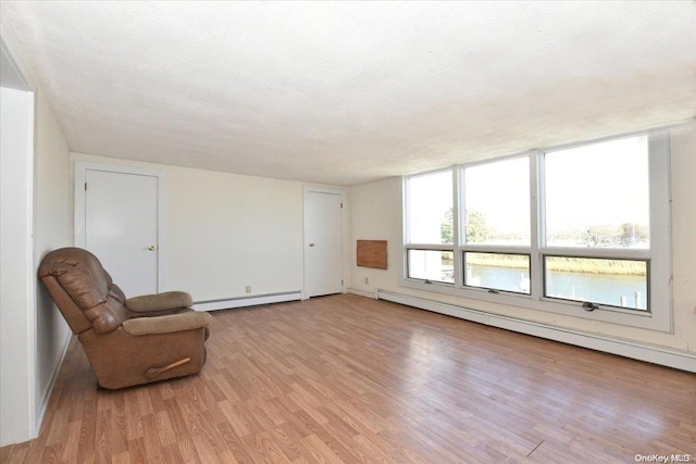 sitting room featuring light hardwood / wood-style floors, a textured ceiling, and a baseboard radiator