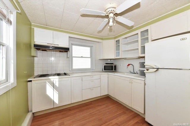 kitchen with white cabinets, decorative backsplash, white appliances, and sink