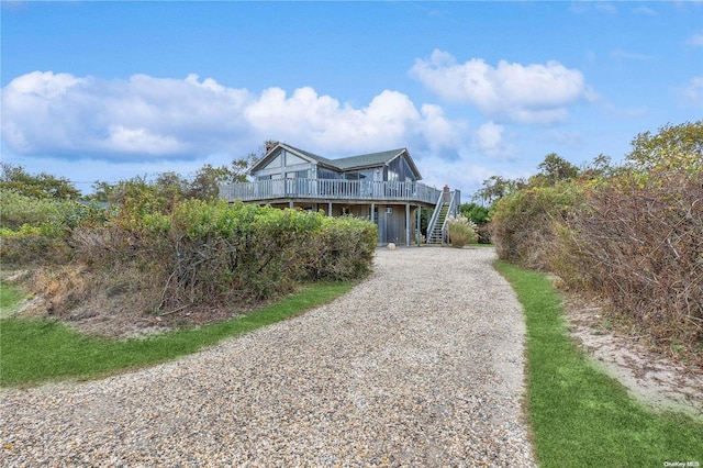 21 Captain Kidds Path, Montauk, NY 11954 - coastal home with stairway, a wooden deck, and gravel driveway