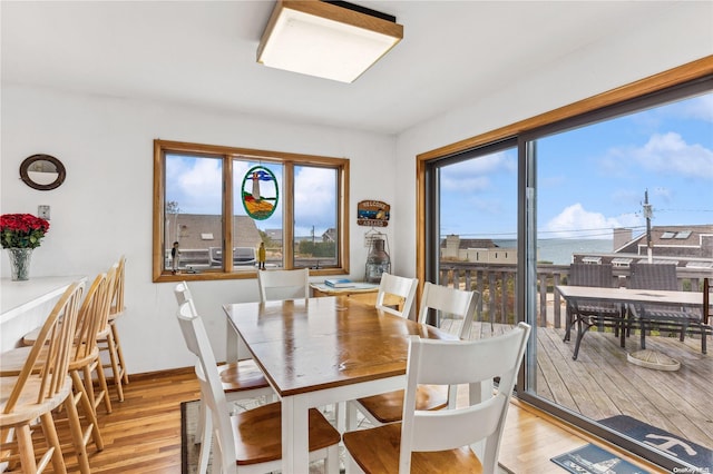 dining space with a water view and light wood-type flooring