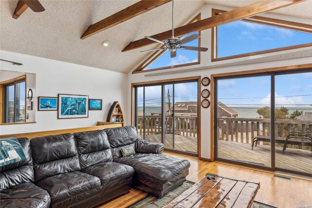 living room with plenty of natural light, beamed ceiling, and hardwood / wood-style flooring