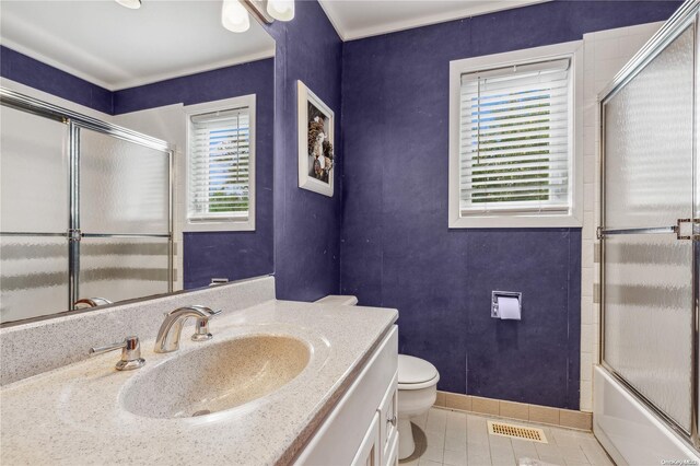 full bathroom with tile patterned flooring, vanity, toilet, and a wealth of natural light