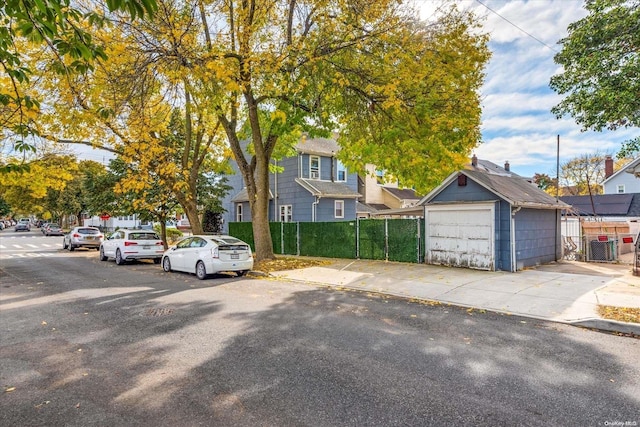 view of front of property featuring cooling unit, a garage, and an outdoor structure