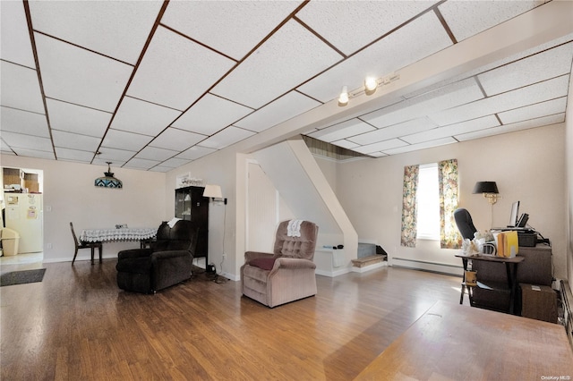 living room featuring hardwood / wood-style floors, a baseboard radiator, and a drop ceiling