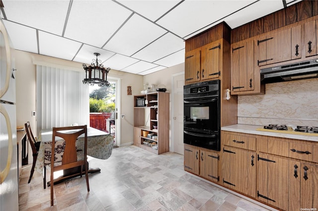 kitchen with backsplash, decorative light fixtures, black oven, and white gas cooktop