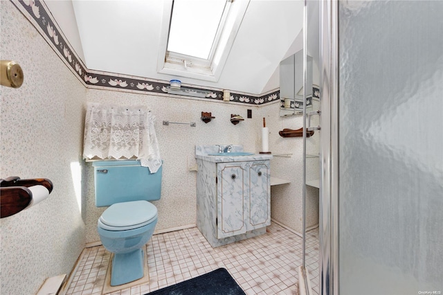 bathroom with tile patterned floors, vanity, toilet, and lofted ceiling with skylight