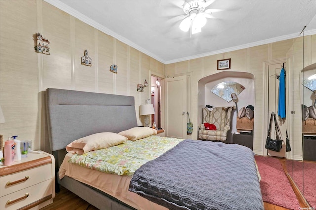 bedroom with dark hardwood / wood-style floors, ceiling fan, and crown molding