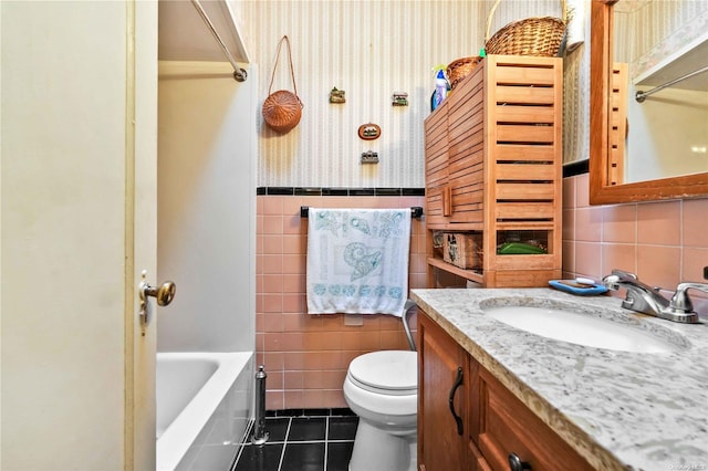 bathroom with tile patterned floors, vanity, tile walls, and toilet