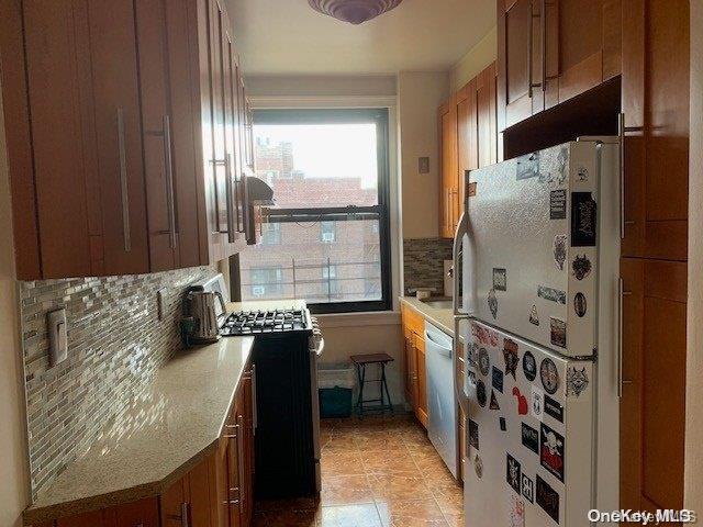 kitchen featuring decorative backsplash, black stove, white fridge, and stainless steel dishwasher