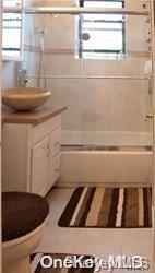 full bathroom featuring toilet, vanity, and combined bath / shower with glass door