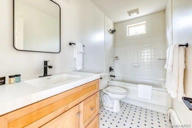 full bathroom featuring vanity, toilet, tiled shower / bath, and a baseboard heating unit