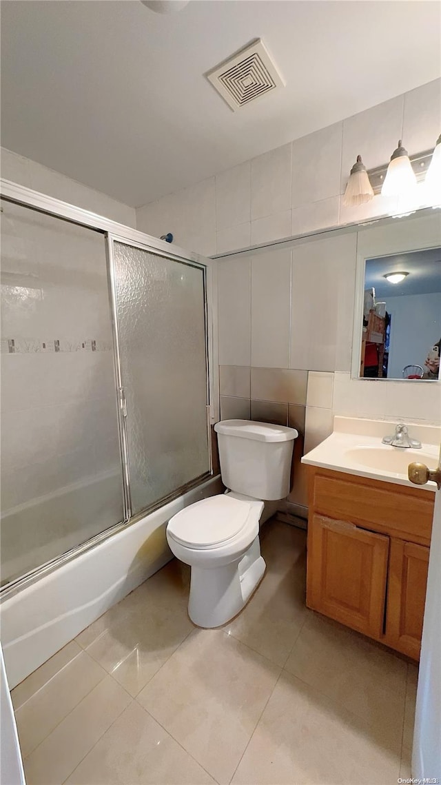 full bathroom featuring tile patterned floors, vanity, enclosed tub / shower combo, and tile walls