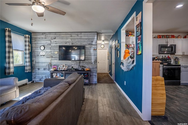 living room with dark hardwood / wood-style flooring, ceiling fan, and wooden walls