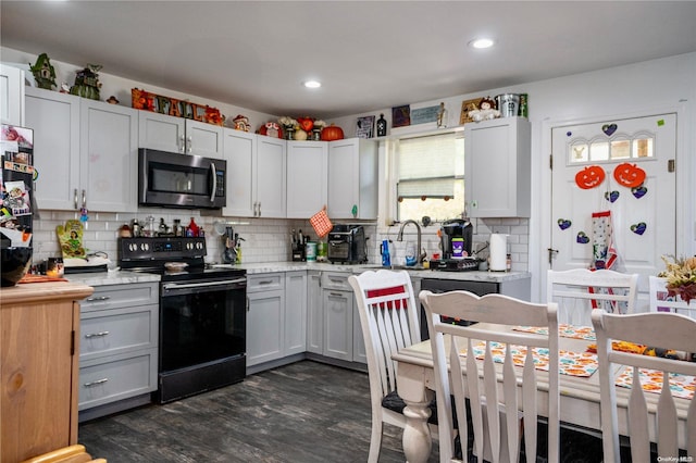 kitchen with dark hardwood / wood-style floors, decorative backsplash, white cabinetry, and black range with electric cooktop