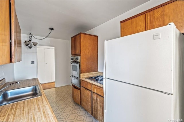 kitchen featuring sink, appliances with stainless steel finishes, and a chandelier