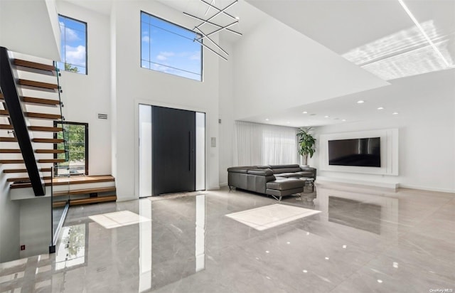 entryway with a towering ceiling and a notable chandelier