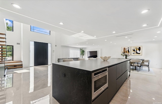 kitchen with elevator, stainless steel microwave, and a large island