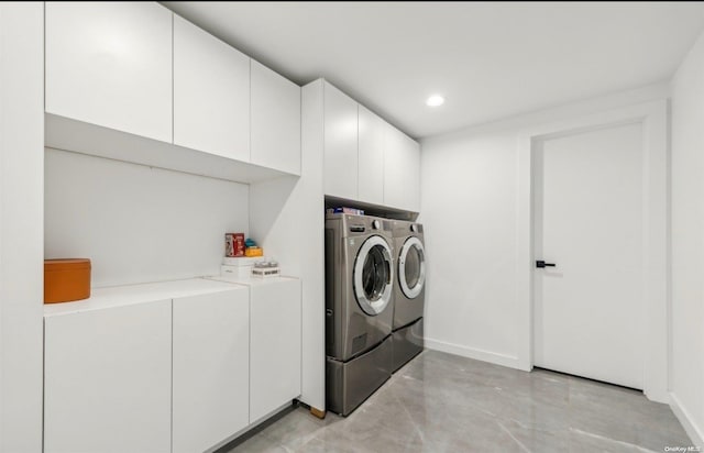 clothes washing area with cabinets and independent washer and dryer