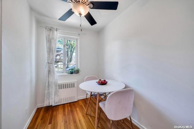 dining space featuring wood-type flooring, radiator, lofted ceiling, and ceiling fan