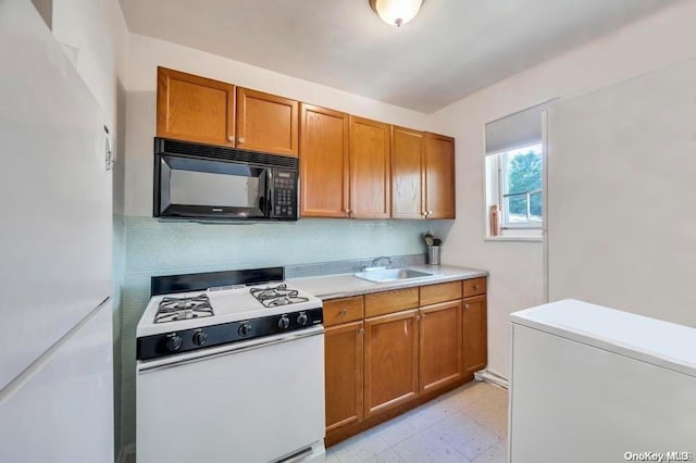 kitchen with decorative backsplash, sink, and white appliances