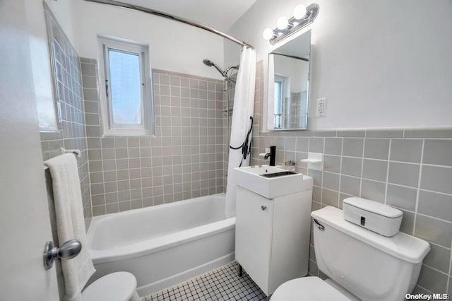 full bathroom featuring shower / bath combo, tile patterned floors, toilet, vanity, and tile walls