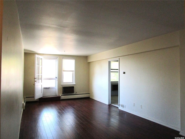 unfurnished room with baseboard heating and dark wood-type flooring