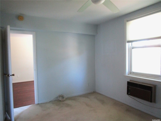 unfurnished room featuring light carpet, a wall mounted AC, and ceiling fan