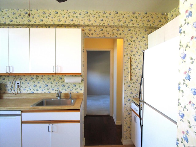 kitchen with sink, white cabinets, and white appliances