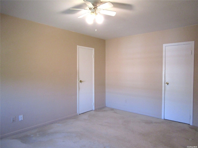 carpeted spare room featuring ceiling fan