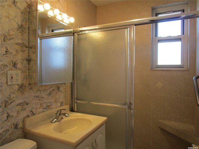 bathroom featuring vanity, toilet, and a shower with door