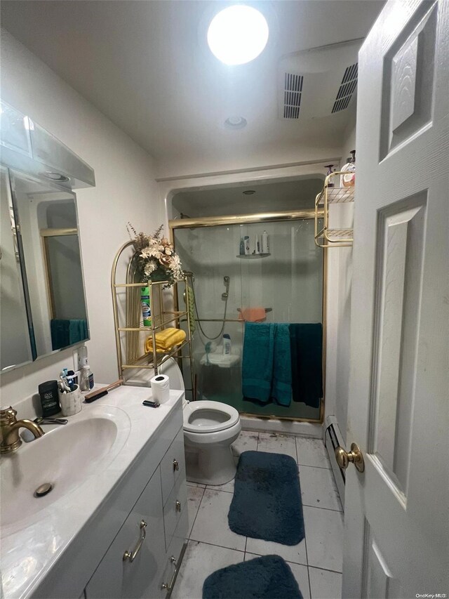 bathroom featuring tile patterned floors, walk in shower, vanity, baseboard heating, and toilet