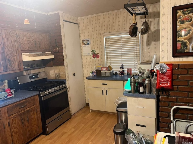 kitchen featuring light wood-type flooring, gas stove, ornamental molding, and range hood