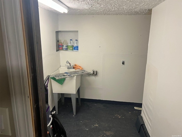 laundry area featuring a baseboard heating unit and a textured ceiling