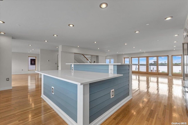 kitchen featuring a spacious island, blue cabinetry, and light hardwood / wood-style flooring