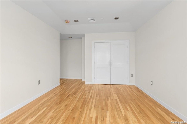 unfurnished bedroom featuring a closet and light hardwood / wood-style flooring