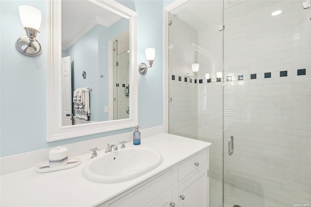 bathroom with crown molding, vanity, and a shower with shower door