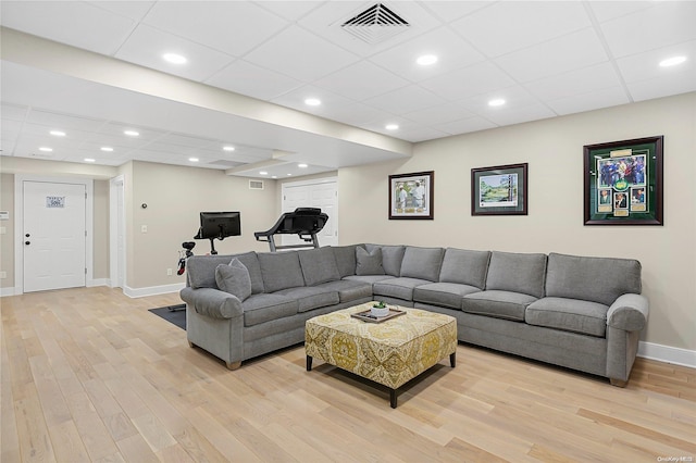 living room featuring a paneled ceiling and light hardwood / wood-style floors