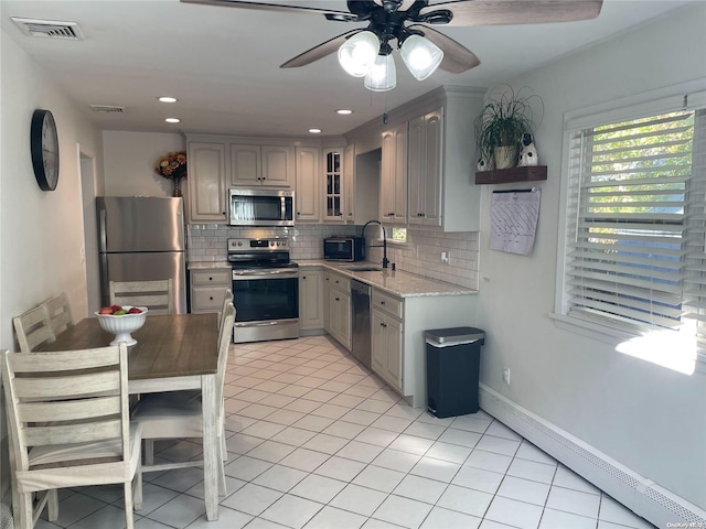 kitchen featuring appliances with stainless steel finishes, tasteful backsplash, gray cabinetry, and sink