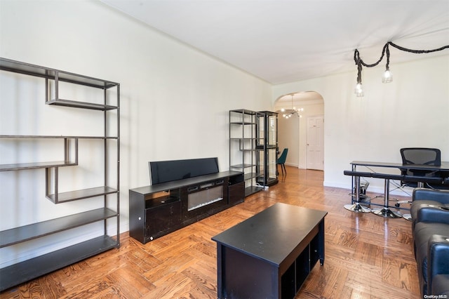 living room featuring parquet flooring and an inviting chandelier